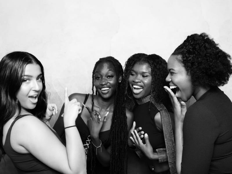 Group of friends laughing during a glam booth session at an New Jersey event