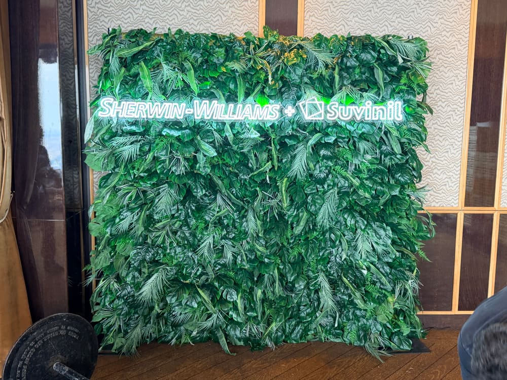 Tropical greenery wall with a Sherwin-Williams and Suvinil neon sign
