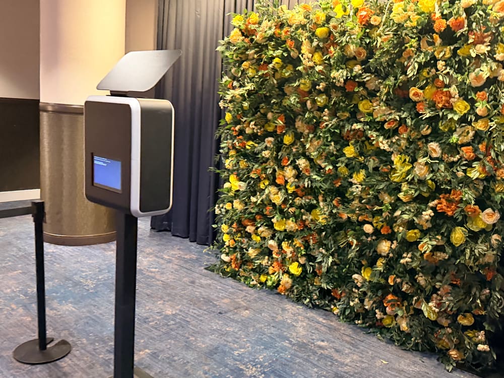 Yellow and orange rose wall beside a photo booth in a hotel ballroom