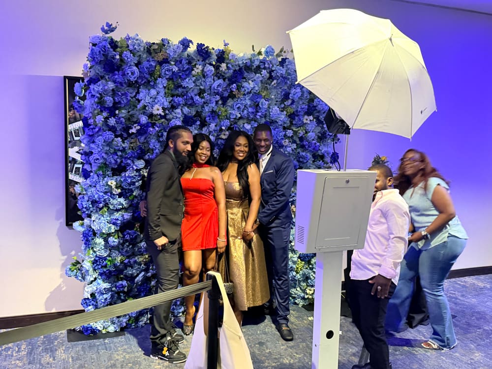 Four guests in evening dress at a blue floral wall