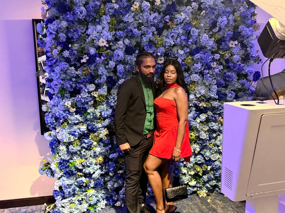Couple posing together at a blue floral wall