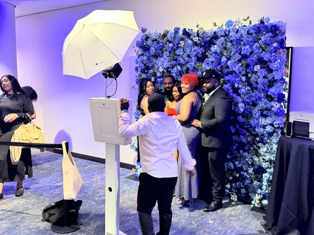Guests gathering for a group shot at a blue floral wall