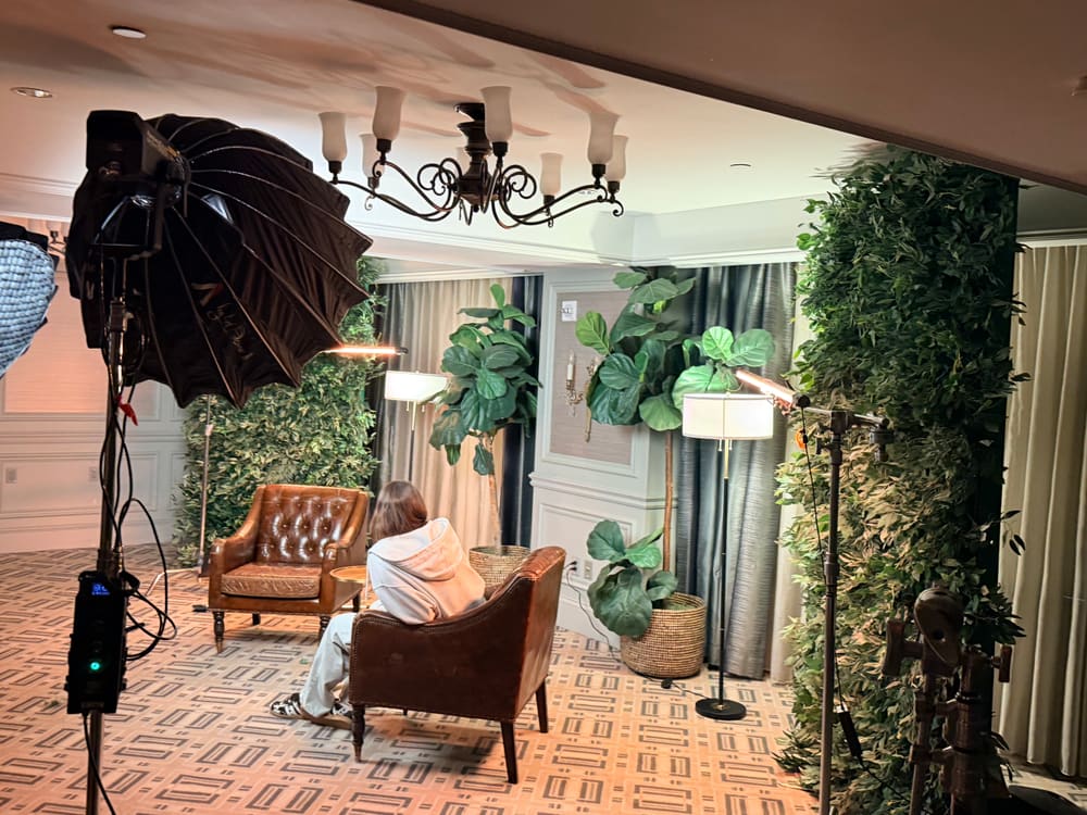 Interview lounge built between two greenery walls under studio lighting