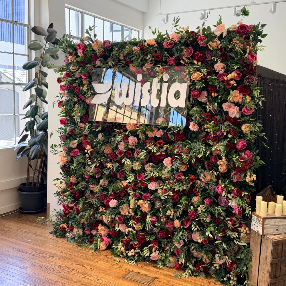 Burgundy and blush rose wall carrying a corporate logo sign