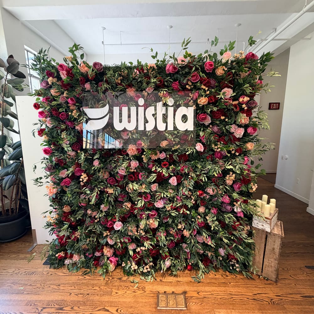 Branded rose wall styled with candles in a loft space